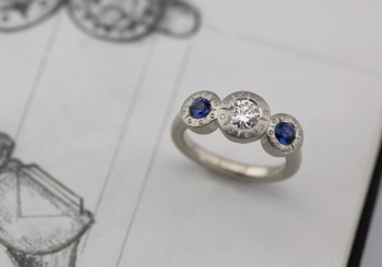 Yogo Sapphire accents and Geometric elements elevate with classic Engagement ring. 