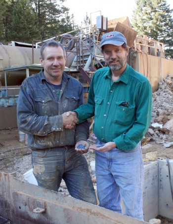 The new Vortex Mine's owner, Mike Roberts, is congratulated by The Gem Gallery's owner, Don Baide, each with a handful of rough Yogo.